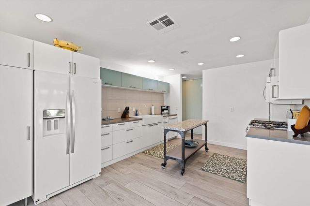 a kitchen with stainless steel appliances a refrigerator sink and stove