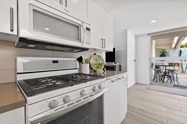 a kitchen with a stove and white cabinets