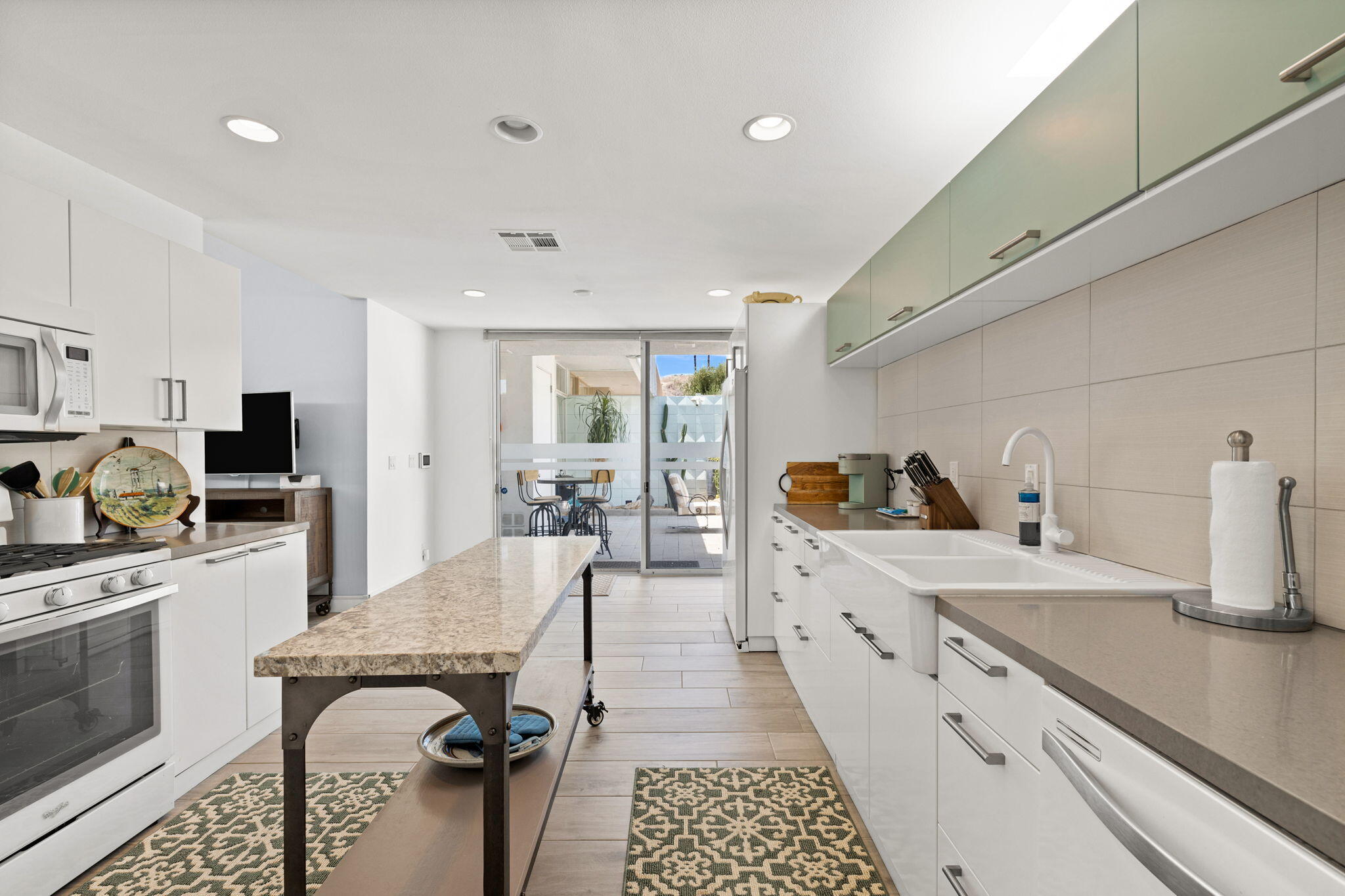 72857 El Paseo, Unit 502 Palm Desert, CA 92260 - Photo 14 of 48 a large kitchen with stainless steel appliances granite countertop a sink dishwasher stove refrigerator and cabinets with wooden floor