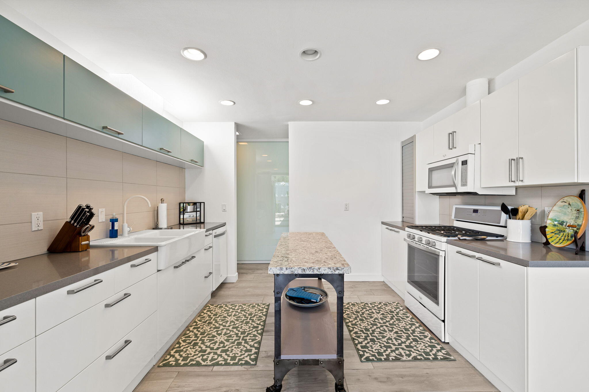 72857 El Paseo, Unit 502 Palm Desert, CA 92260 - Photo 16 of 48 a large white kitchen with sink and stainless steel appliances