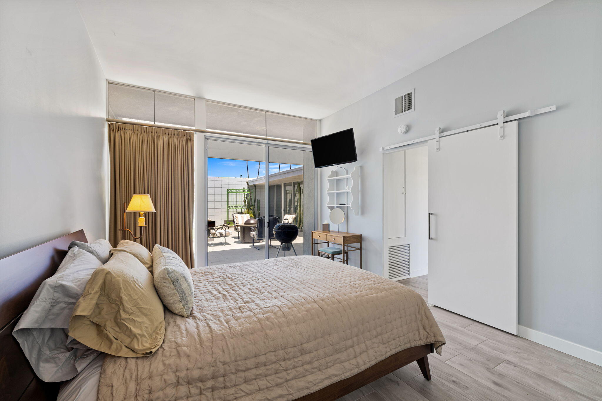 72857 El Paseo, Unit 502 Palm Desert, CA 92260 - Photo 20 of 48 a bedroom with a bed and a walk in closet with wooden floor