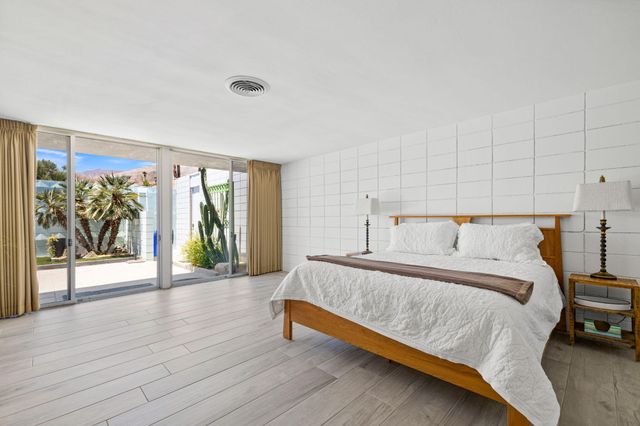 a spacious bedroom with a bed and a large window