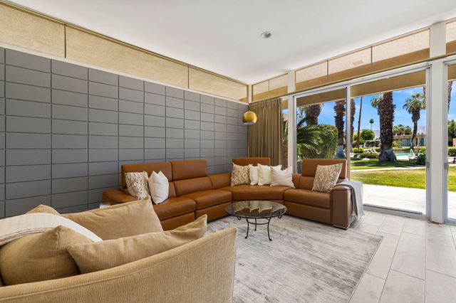 a living room with furniture and a floor to ceiling window
