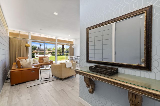 a living room with furniture and a floor to ceiling window