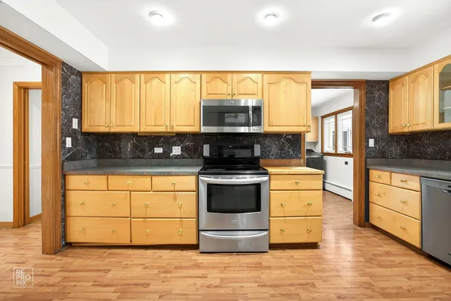 a kitchen with stainless steel appliances granite countertop a stove and cabinets