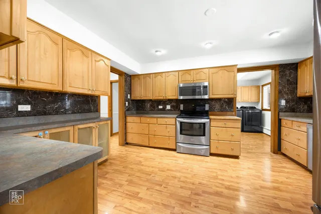 a kitchen with stainless steel appliances granite countertop a stove a sink and a microwave
