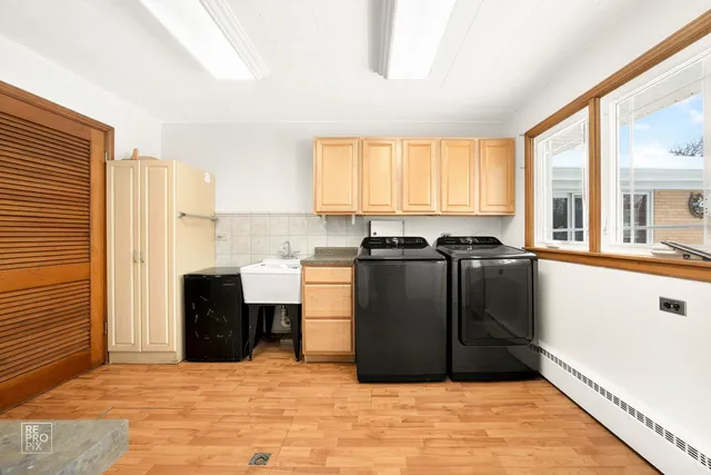 a view of a kitchen with kitchen island a sink wooden floor and black appliances