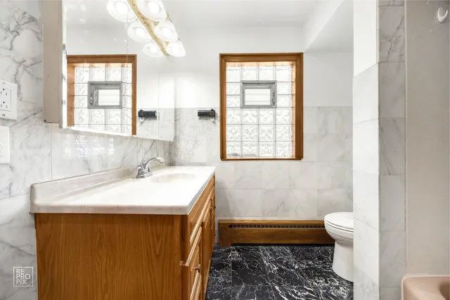 a bathroom with a sink a toilet and a window