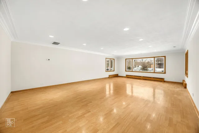 a view of an empty room with a window and fire place