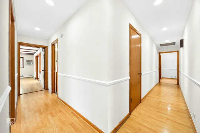 a view of hallway with furniture and wooden floor