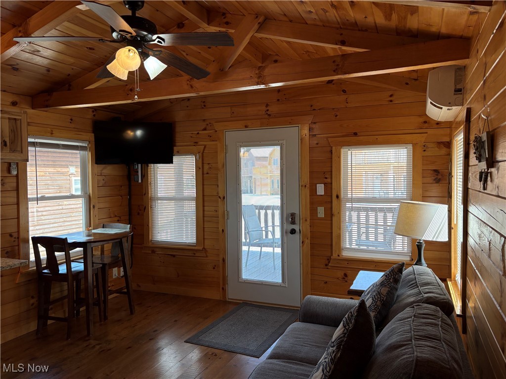 5919 Lake Road West, Unit 15 Ashtabula, OH 44004 - Photo 13 of 26 Living area with wooden ceiling, wood finished floors, a ceiling fan, wooden walls, and a wall mounted AC