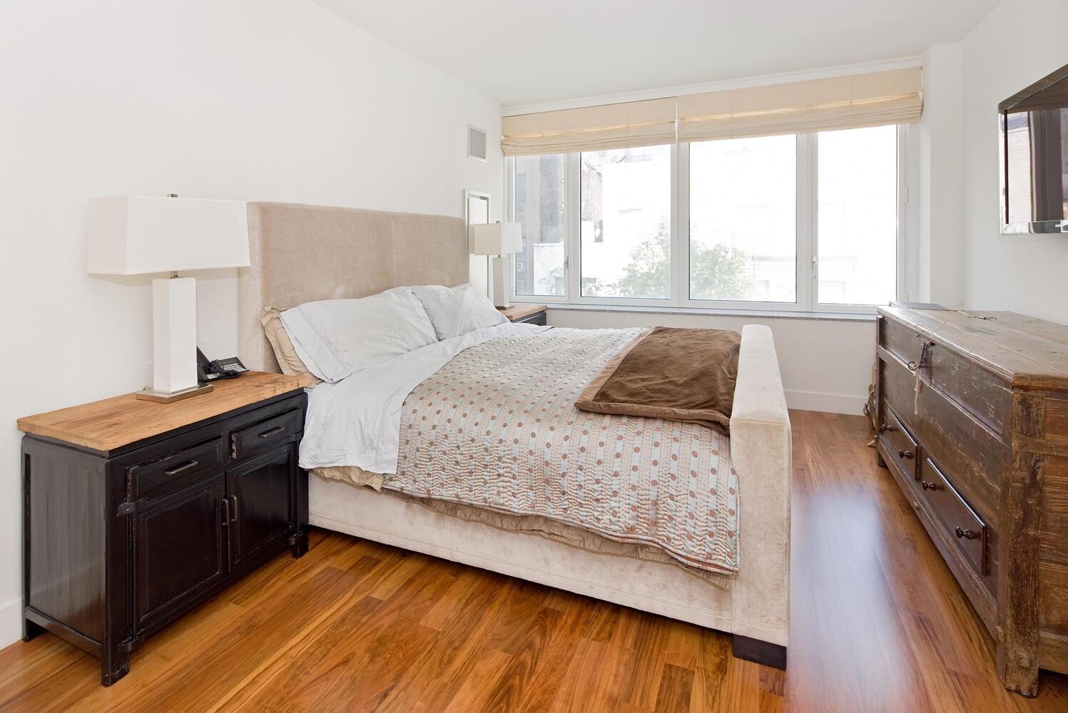 250 East 53rd Street, Unit 404 Manhattan, NY 10022 - Photo 3 of 12 a bedroom with a bed and a dresser next to a window