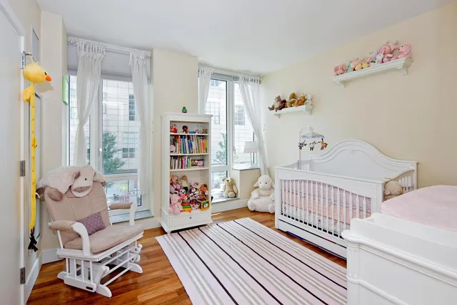 a bedroom with baby toys and wooden floor