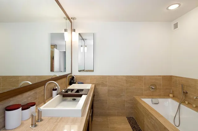 a bathroom with a tub sink and mirror