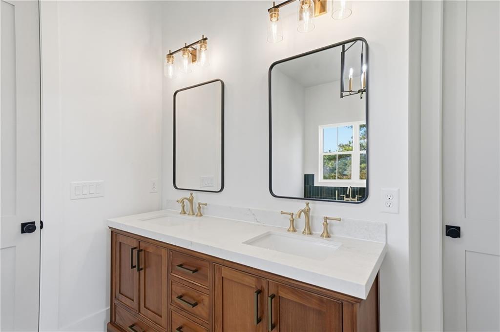 1248 Avery Road Canton, GA 30115 - Photo 44 of 64 a bathroom with double vanity sinks and a mirror