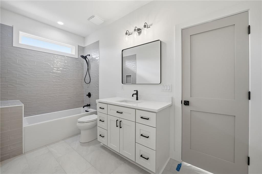1248 Avery Road Canton, GA 30115 - Photo 57 of 64 a bathroom with a toilet a sink a mirror a bathtub and vanity