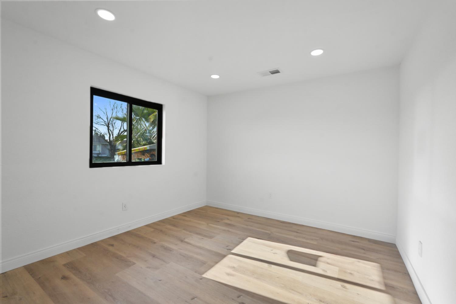 43 Skylark Street Merced, CA 95341 - Photo 6 of 14 an empty room with wooden floor and window