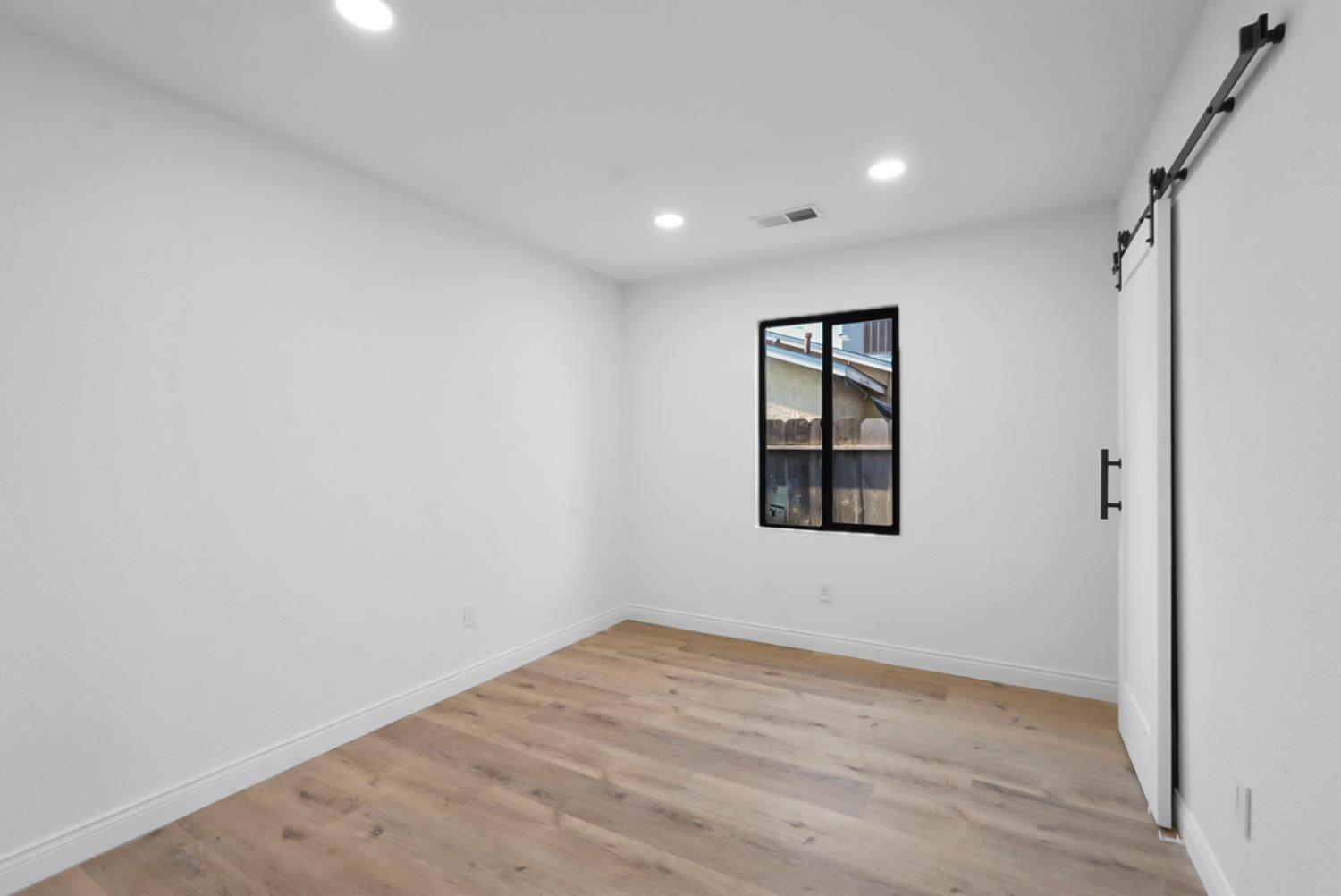 43 Skylark Street Merced, CA 95341 - Photo 7 of 14 an empty room with a window and wooden floor