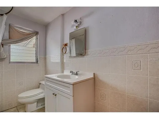 a bathroom with a sink toilet and mirror