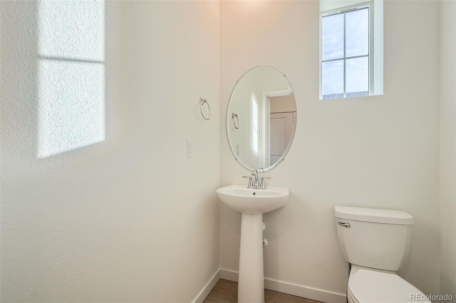 1979 South Gold Bug Way Aurora, CO 80018 - Photo 14 of 28 a bathroom with a toilet a sink and a mirror