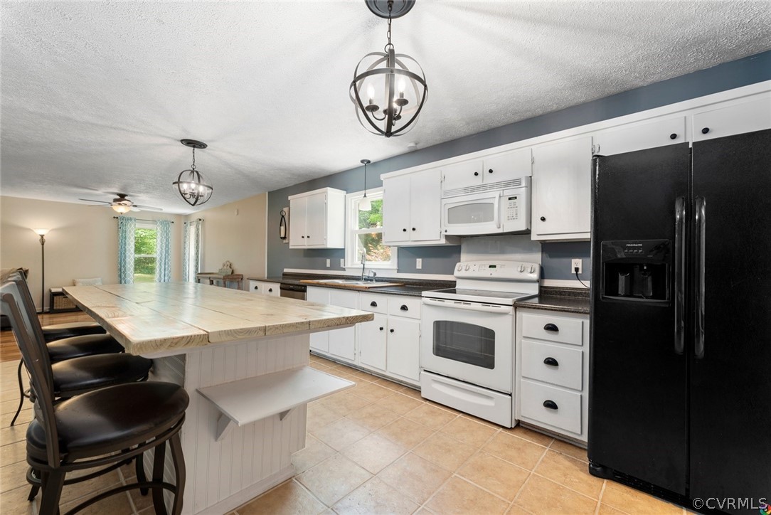 13571 Bailey Bridge Road Midlothian, VA 23112 - Photo 18 of 46 a kitchen with stainless steel appliances a white center island a stove a refrigerator cabinets and a dining table