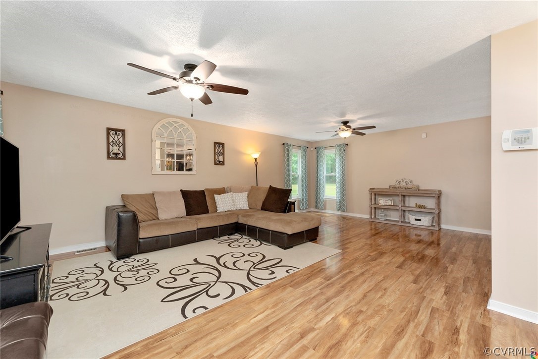 13571 Bailey Bridge Road Midlothian, VA 23112 - Photo 8 of 46 a living room with furniture and a flat screen tv with wooden floor
