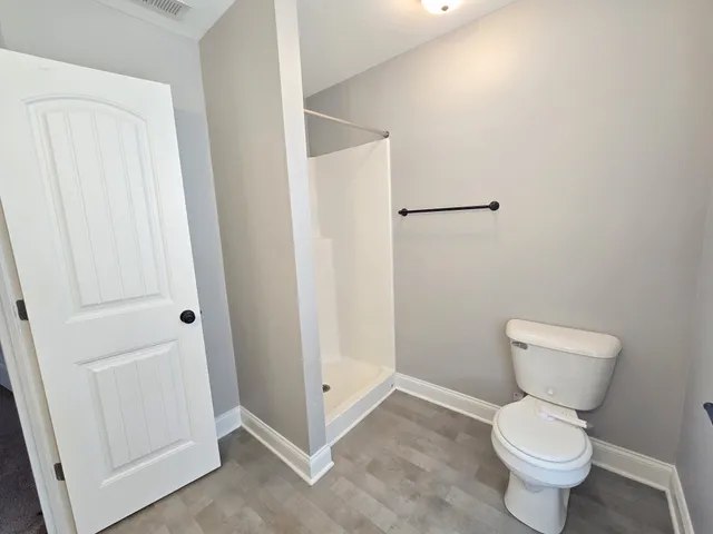 a white toilet sitting next to a white cabinet