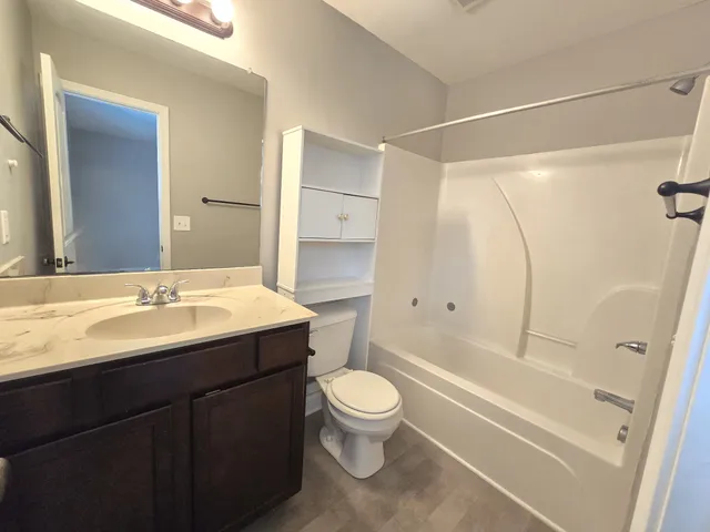 a bathroom with a sink a toilet and a large mirror