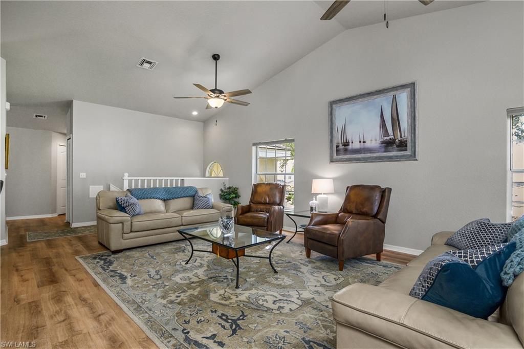 13061 Hamilton Harbour Drive, Unit R1 Naples, FL 34110 - Photo 11 of 23 Living room with wood finished floors, ceiling fan, and high vaulted ceiling