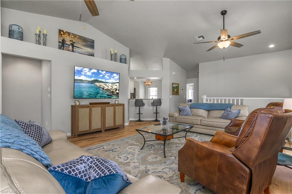 13061 Hamilton Harbour Drive, Unit R1 Naples, FL 34110 - Photo 12 of 23 Living area with ceiling fan, wood finished floors, and high vaulted ceiling
