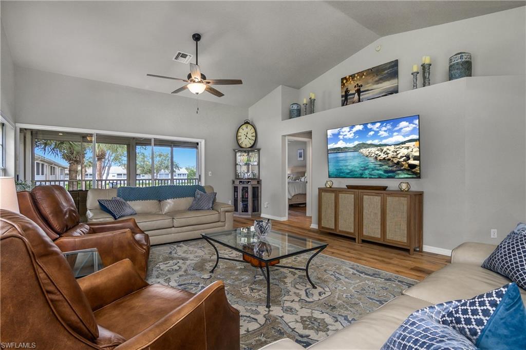 13061 Hamilton Harbour Drive, Unit R1 Naples, FL 34110 - Photo 13 of 23 Living area featuring wood finished floors, a ceiling fan, and high vaulted ceiling