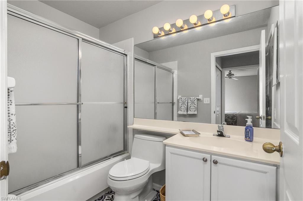 13061 Hamilton Harbour Drive, Unit R1 Naples, FL 34110 - Photo 15 of 23 Full bath featuring bath / shower combo with glass door, vanity, and ceiling fan