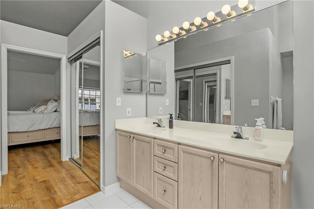 13061 Hamilton Harbour Drive, Unit R1 Naples, FL 34110 - Photo 21 of 23 Ensuite bathroom featuring double vanity and light tile patterned floors