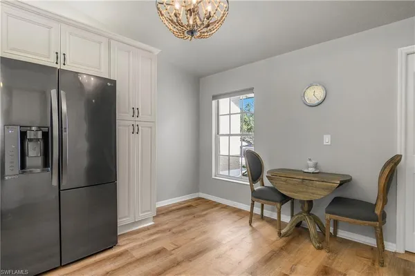 a view of a dining room with furniture a chandelier and wooden floor