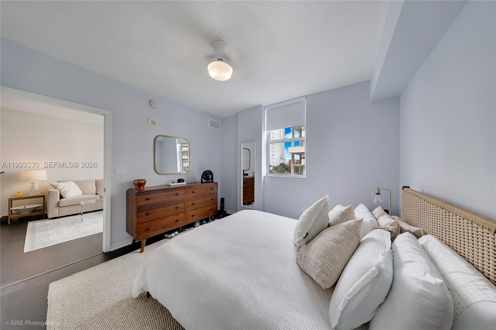 115 Southwest 11th Street, Unit 505 Miami, FL 33130 - Photo 8 of 12 a bedroom with a bed large mirror and window