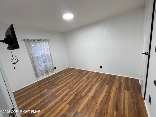a view of a room with wooden floor and cabinet