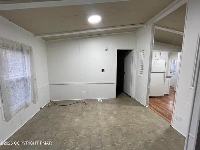 a room with lots of wooden furniture and a fan