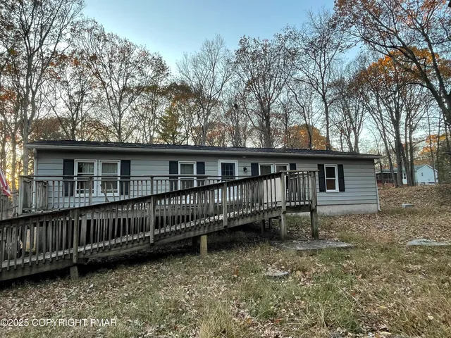 a view of house with a yard and wooden fence