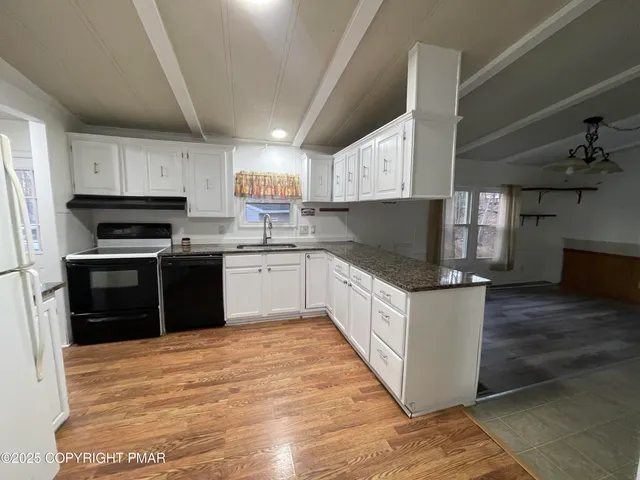 a kitchen with granite countertop stainless steel appliances and refrigerator