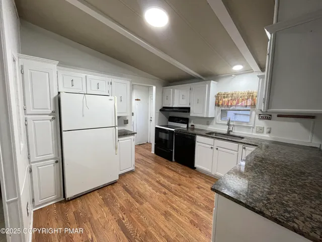 a view of a room with wooden floor and ceiling fan