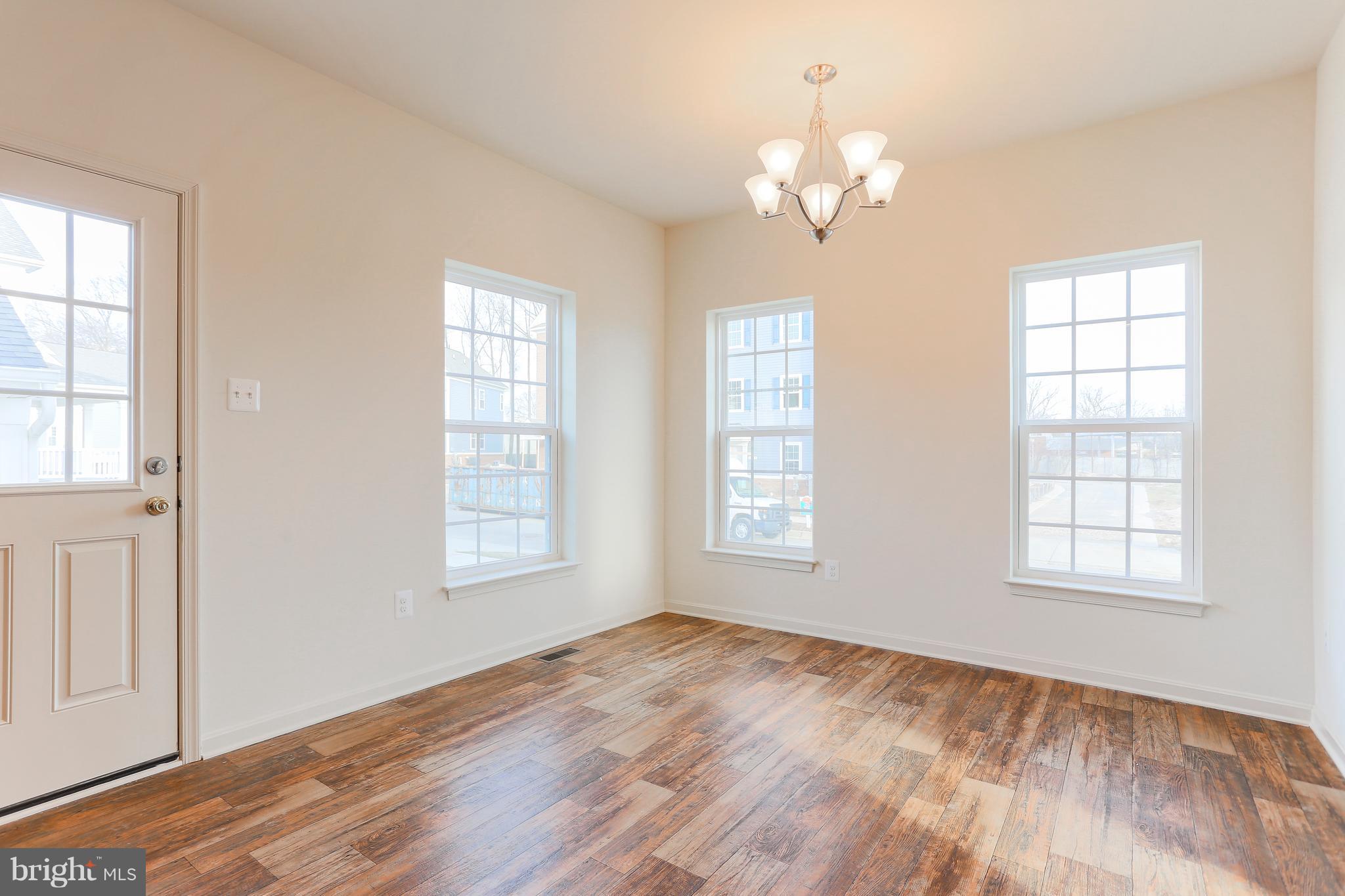 7 Back River Neck Road Baltimore, MD 21221 - Photo 24 of 29 an empty room with wooden floor chandelier and windows