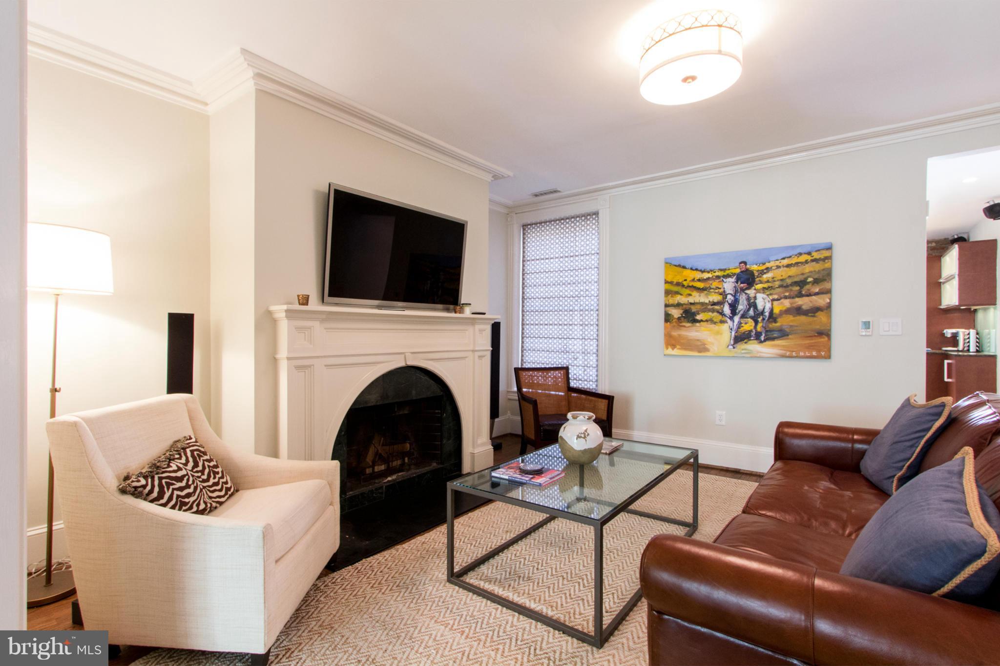 124 3rd Street Northeast Washington, DC 20002 - Photo 7 of 30 a living room with furniture a flat screen tv and a fireplace
