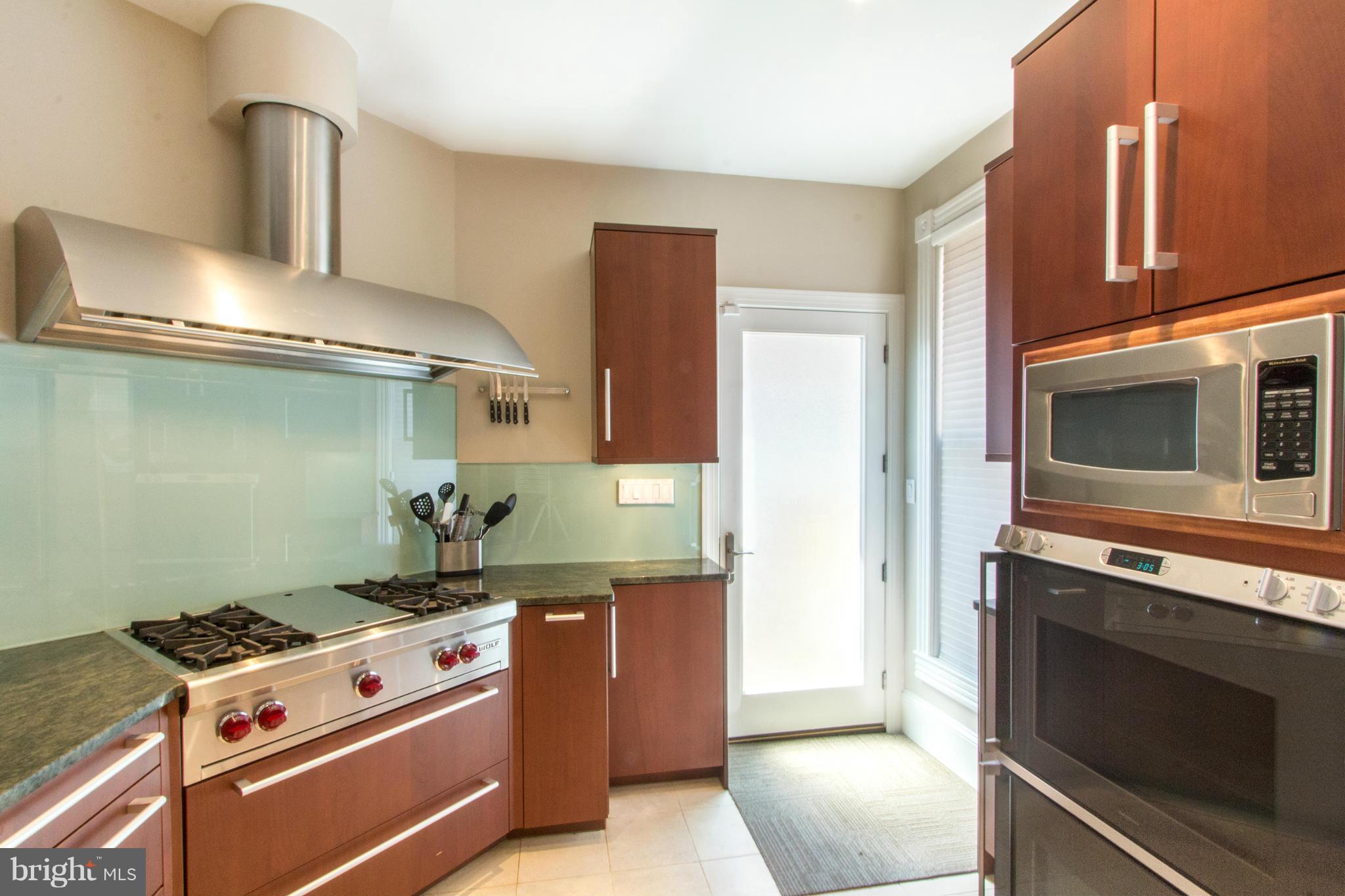 124 3rd Street Northeast Washington, DC 20002 - Photo 9 of 30 a kitchen with stainless steel appliances granite countertop a stove and a microwave