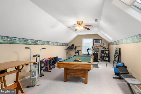 a front view of a house with garden and trees