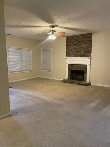 an empty room with a fireplace and fan
