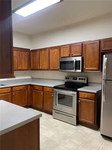 a kitchen with stainless steel appliances granite countertop a stove microwave and sink
