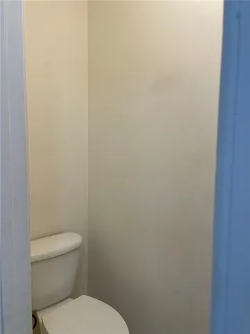 a white toilet sitting next to a white cabinet