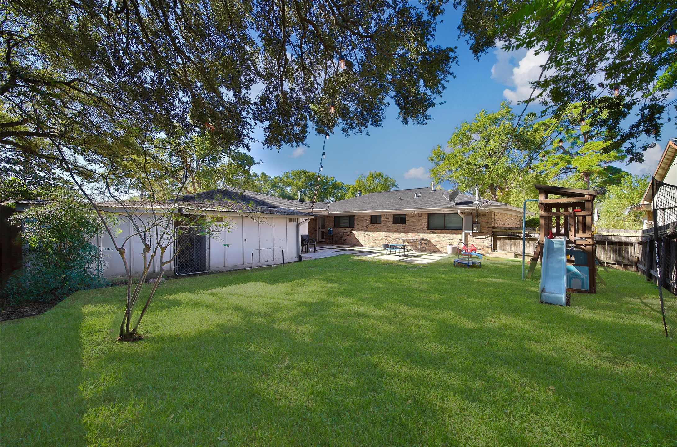4402 Fallbrook Drive Houston, TX 77018 - Photo 6 of 29 Expansive yard featuring a shaded tree canopy, patio space, and room for outdoor activities. Access to the extra storage behind the garage.