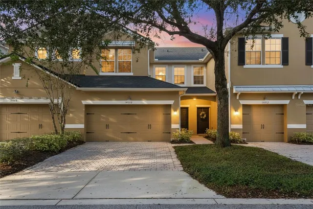 a front view of a house with a yard and a garage