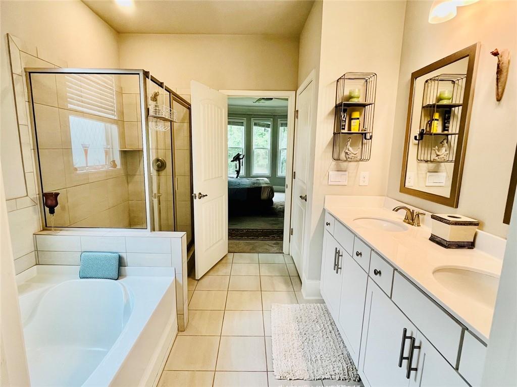 3015 Winding Ridge Waleska, GA 30183 - Photo 17 of 40 a spacious bathroom with a granite countertop tub sink a mirror a shower and a bathtub